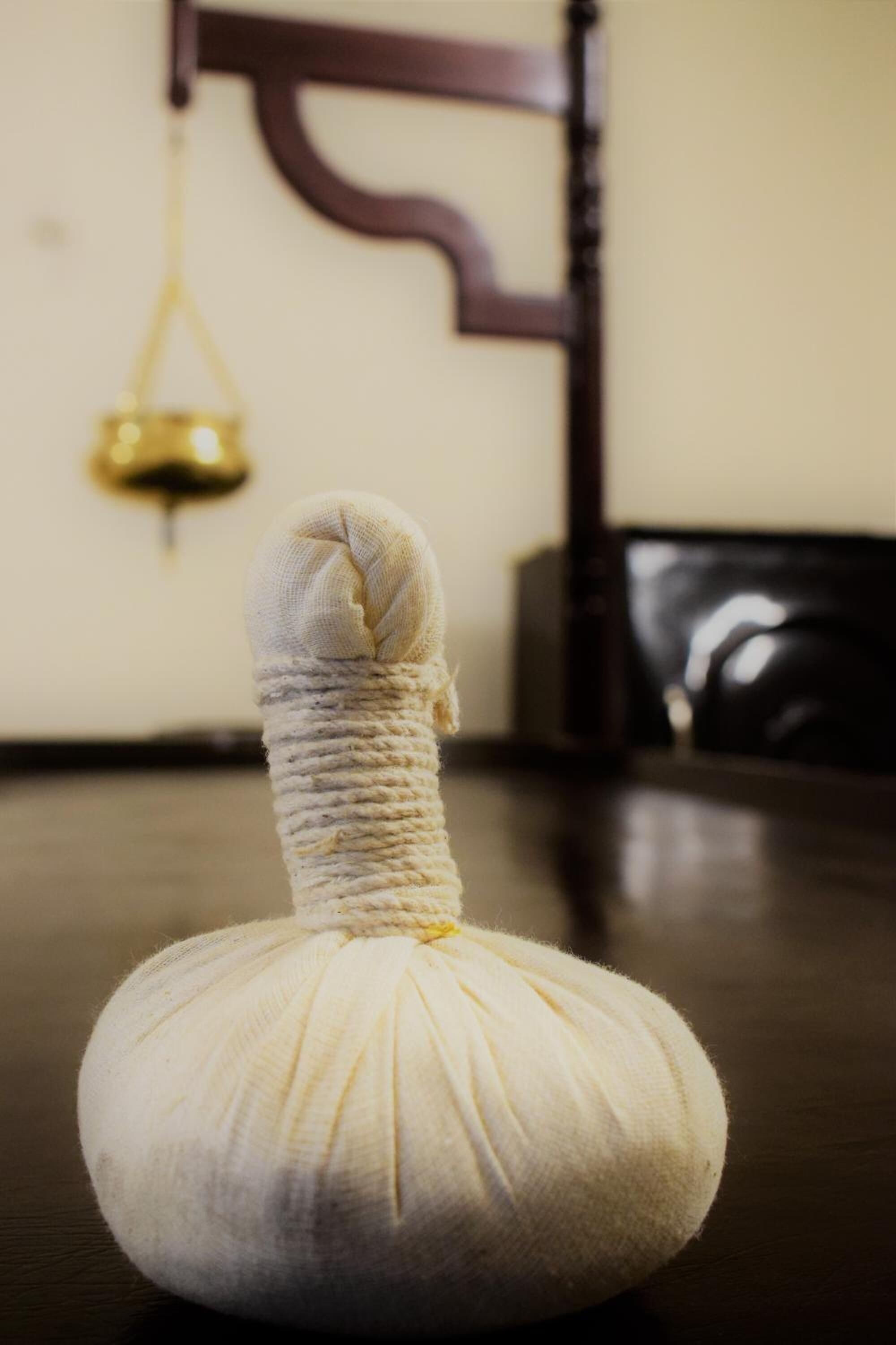 A massage ball on a wooden table with a chair and a wall-mounted object in the background.