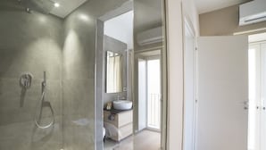 A modern bathroom with a shower, a sink, and a mirror. - Suite Dreams (Agrigento)