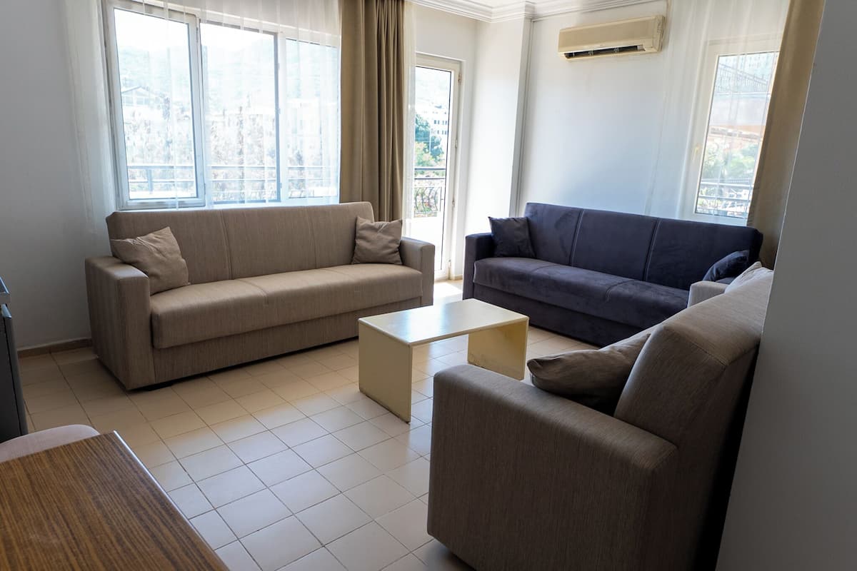 A living room with two sofas, a coffee table, and a view of the outside.
