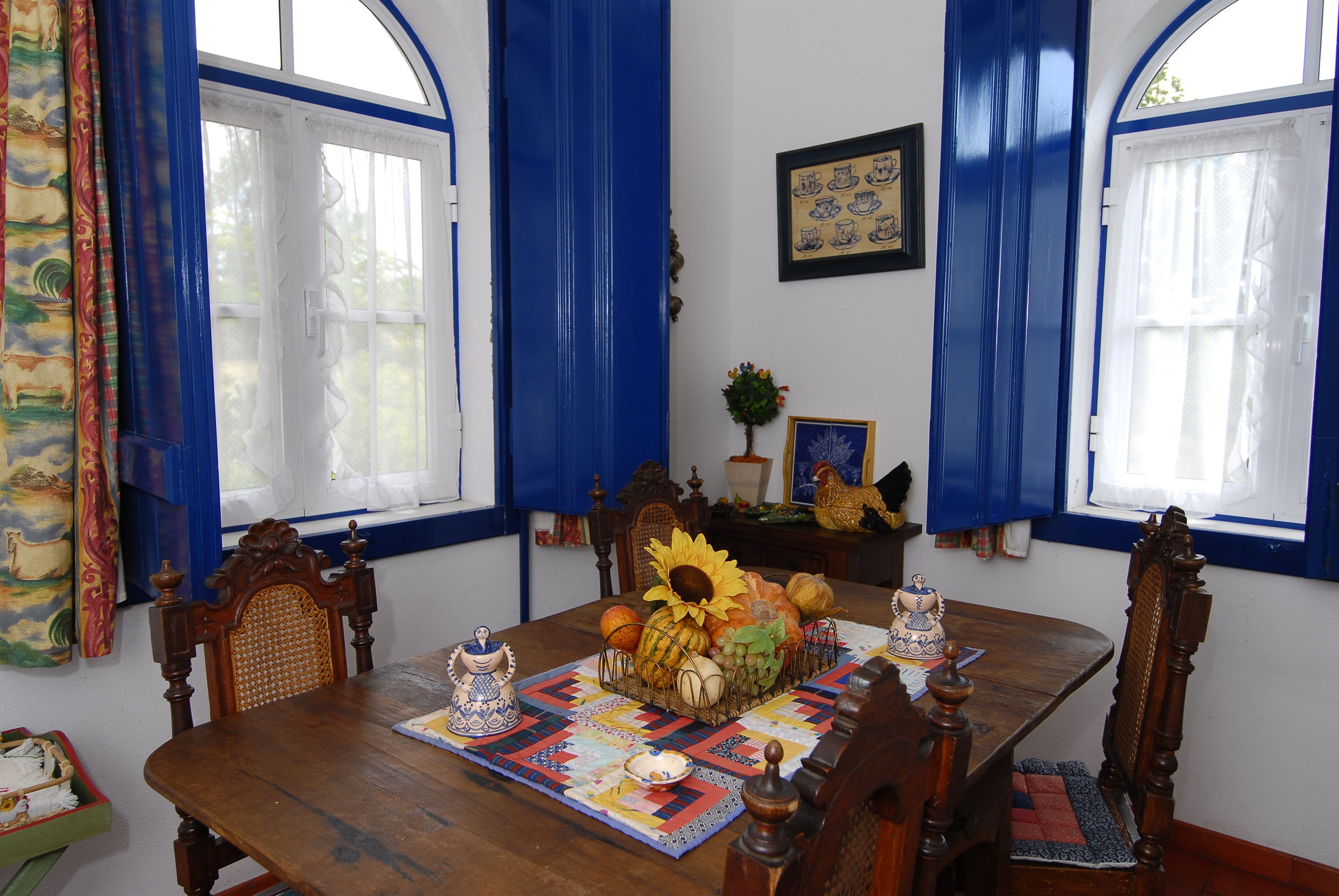 Una mesa de comedor con un centro de mesa floral, rodeada de sillas de madera.