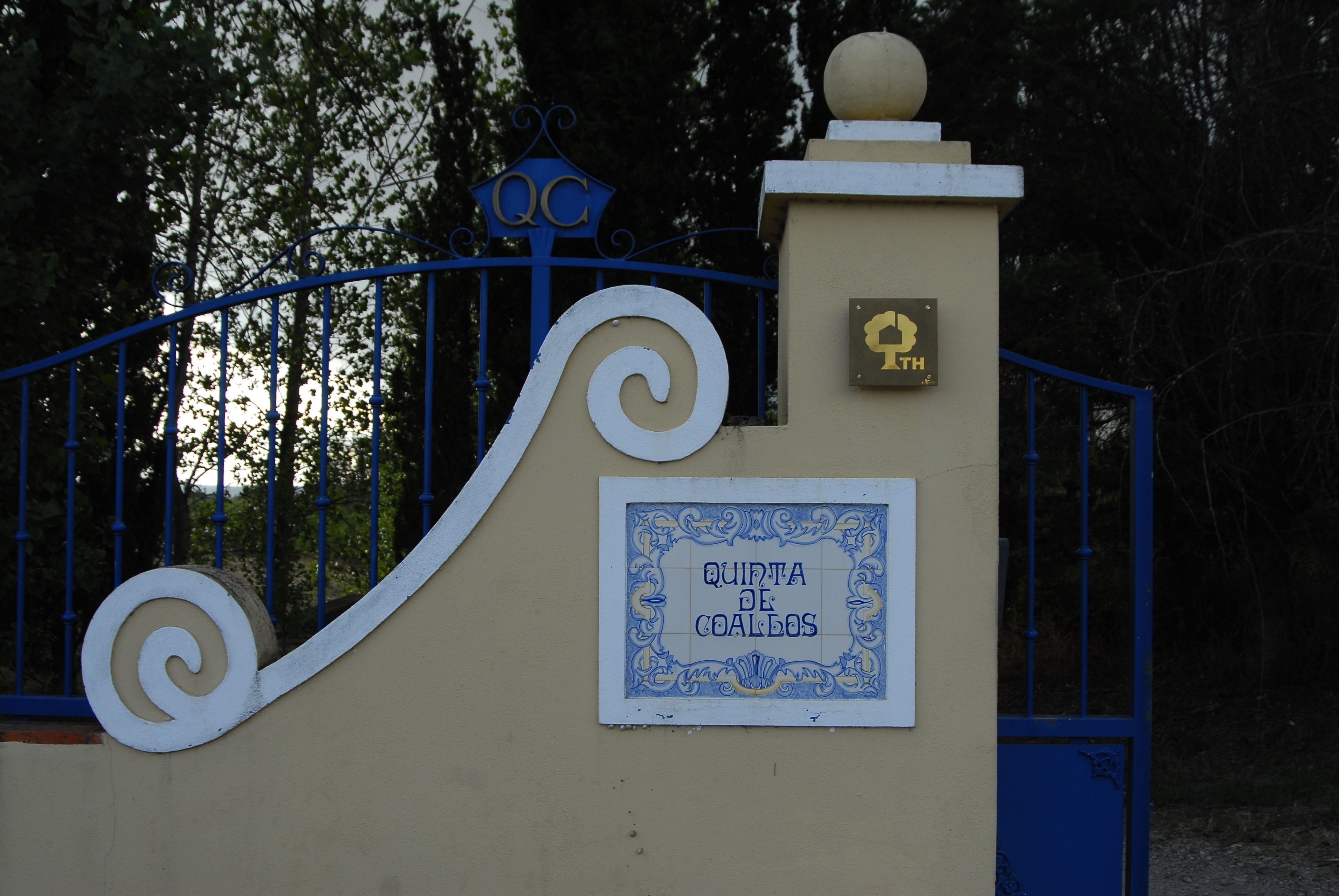A gate with a sign reading "QUINTA DE COALDOS" and a plaque with a symbol.