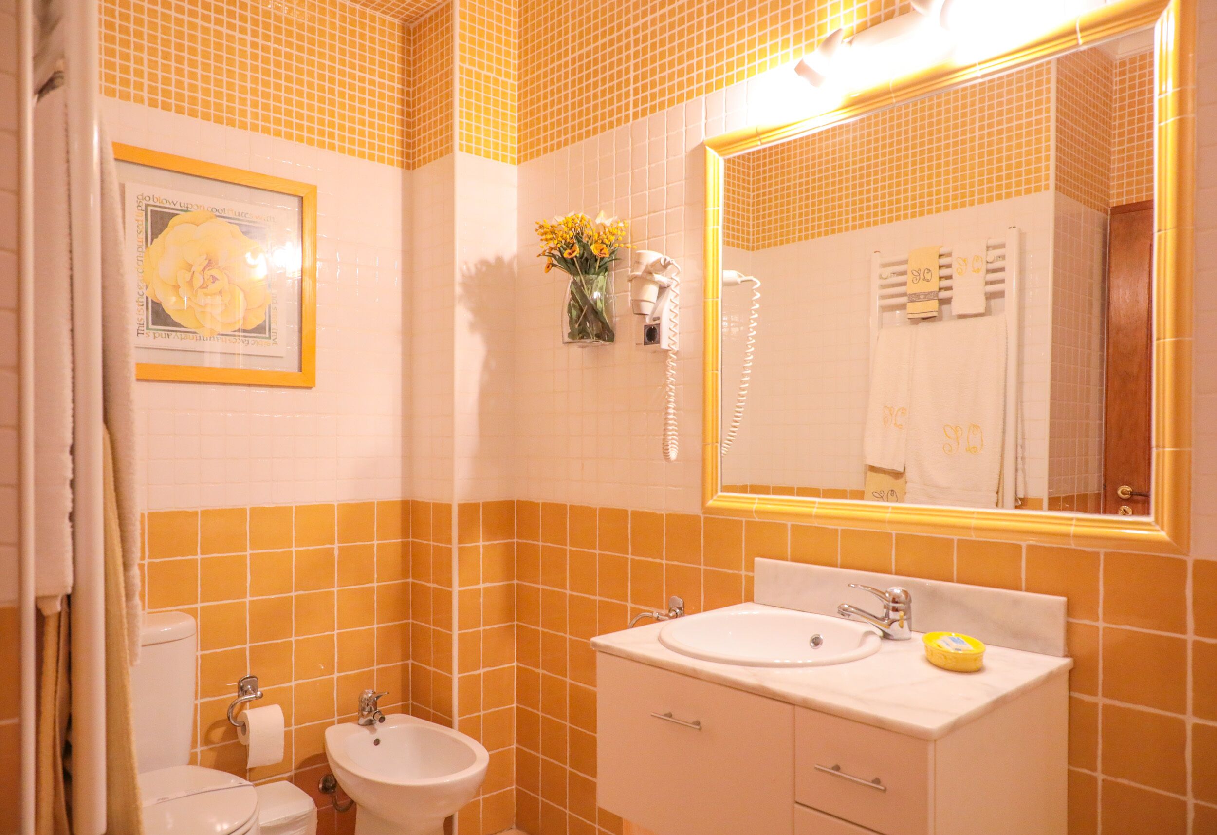 Un bany amb vàter, bidet, rentapel i un mirall gran.