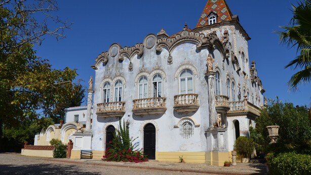Un bâtiment historique à l’architecture riche et élaborée, avec de nombreux balcons et des fenêtres en arc de cercle.