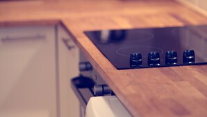 Eine Küche mit Holzarbeitsplatte, einem Herd, einem Wasserkocher und einem Toaster.