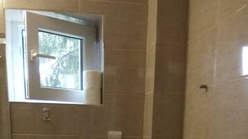 Un bagno con il water, un lavandino e una finestra.