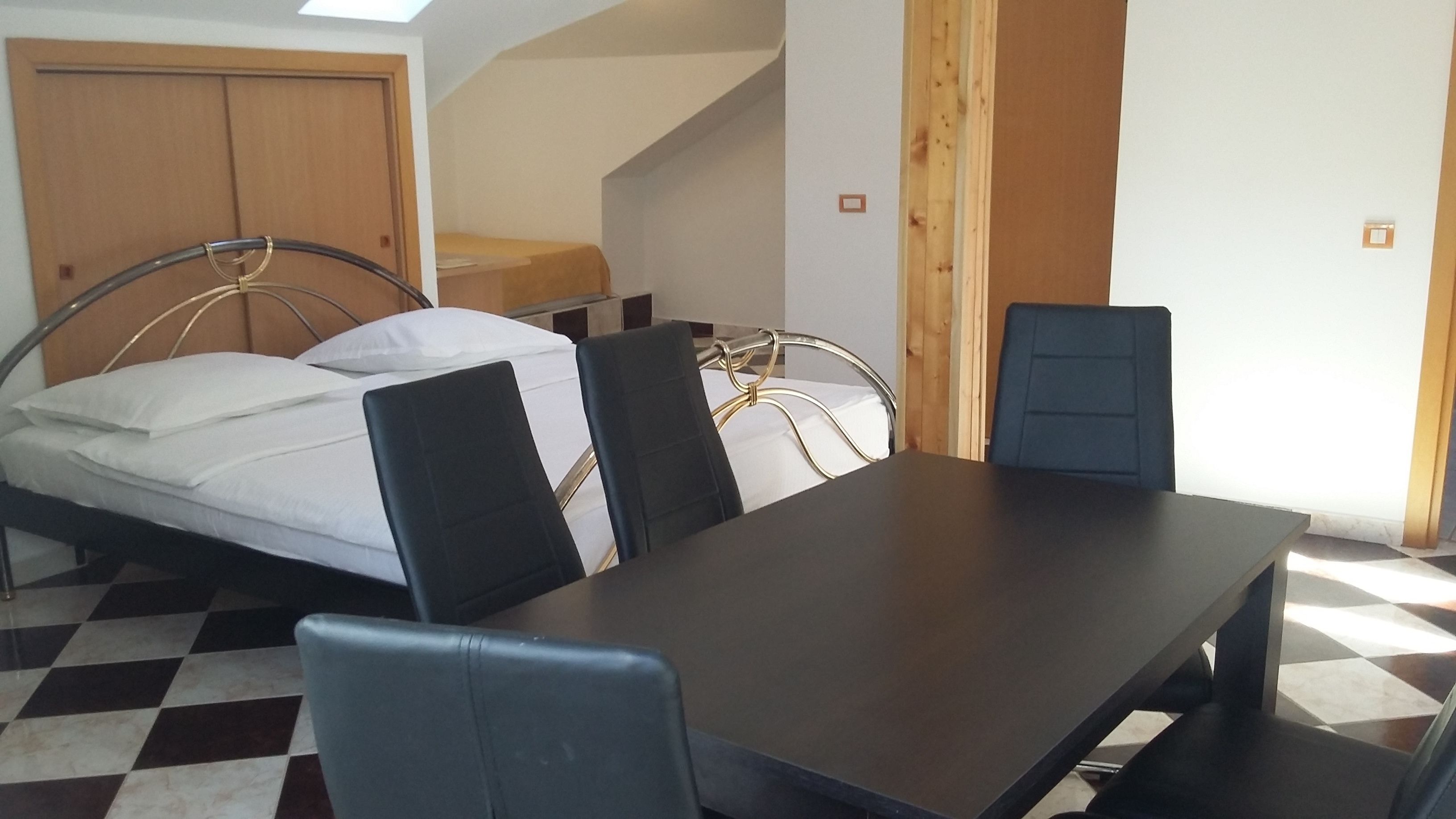 Una habitación con una cama, una mesa y dos sillas.