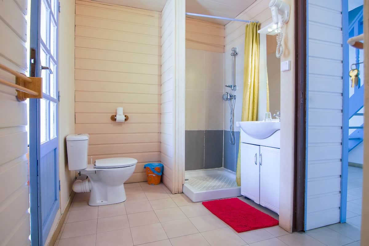 Un baño pequeño con inodoro, ducha y lavamanos.