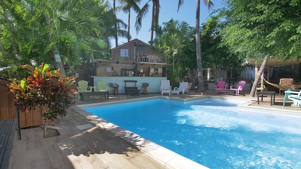 A swimming pool with lounge chairs and a bar area. - Hotel Coco Island (Saint-Paul)