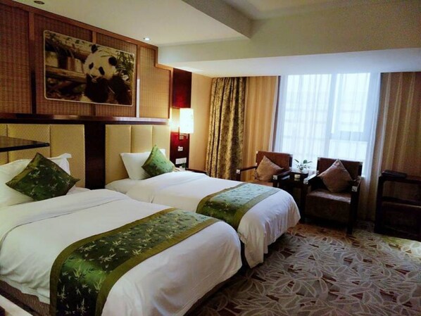 A hotel room with two beds, a large panda artwork on the wall, a desk with a chair, and a window with curtains.