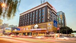 Ein mehrstöckiges Hotel mit einem Panda-Logo, das auf ein Panda Prince Hotel hinweist. Es verfügt über eine moderne Fassade mit großen Fenstern und einem markanten Eingang.