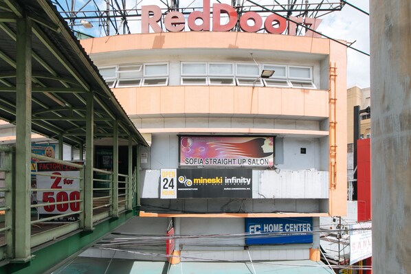 A building with a RedDoor sign, a Sofia Straight Up Salon, and a FC Home Center. - RedDoorz Plus @ EDSA Congressional (Quezon City)