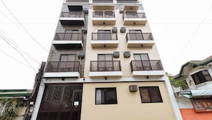 A multi-story residential building with balconies, air conditioning units, and a gated entrance. - RedDoorz near NAIA Terminal 1 (Parañaque)