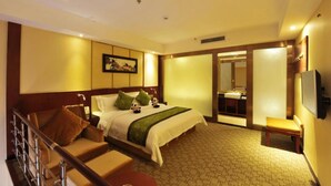A hotel room with a bed, a sofa, a TV, and a bathroom visible through a sliding door. - Panda Prince Hotel Suining Branch (Suining)