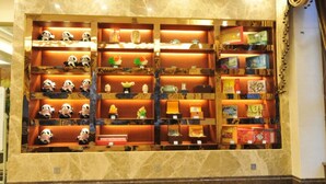 A display of panda plush toys and various books on shelves. - Panda Prince Hotel Suining Branch (Suining)