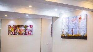Un pasillo con dos grandes cuadros abstractos en las paredes.