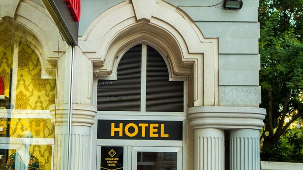 Fachada del hotel Square Inn con un letrero llamativo, arquitectura clásica y entrada de vidrio.