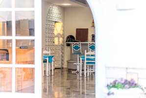 Un interior moderno con una recepción, una pared con diseño y un área de estar con sillas.