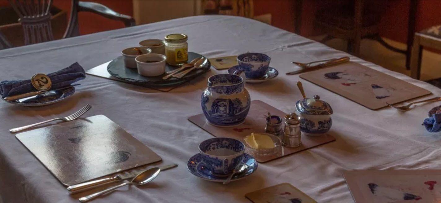 A table set with blue and white porcelain dishes, silverware, and a tray with condiments.