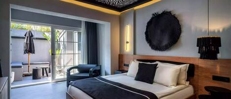 A modern hotel room with a zebra-patterned ceiling, a large bed with black and white bedding, a round black wall decoration, and a view of the outdoors through a sliding door.
