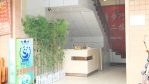 Uma área de recepção com balcão, escada e planta.