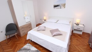 Une chambre à coucher comprenant un lit, des tables de chevet, une armoire et une chaise.