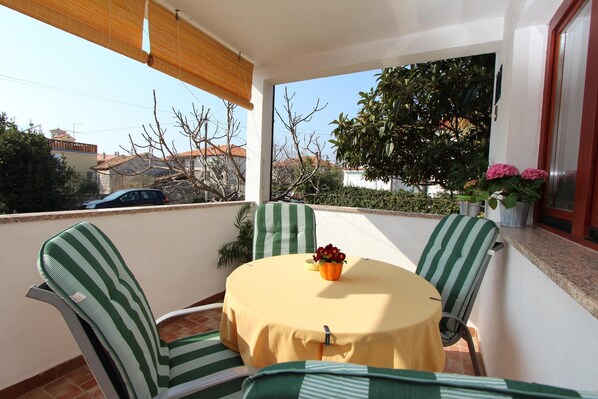 A balcony with a round table, green-striped chairs, a yellow tablecloth, and potted plants. - SAN FRANCESCO Two-Bedroom Apartment 1 (Marija B.) (Rovinj)