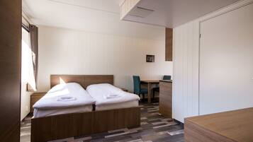 Een hotelkamer met een tweepersoonsbed, een bureau en een stoel.