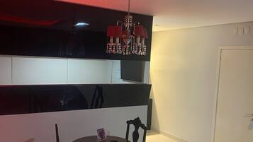Uma sala de jantar com uma mesa redonda, duas cadeiras e um candelabro.