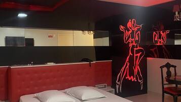 Una camera da letto moderna con una testiera rossa, un letto grande e una parete con arte neon rossa.