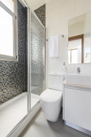 Ducha, bañera de hidromasaje, toallas, shampoo