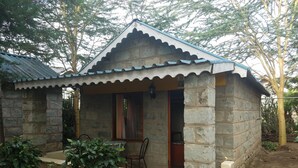 A stone building with a tiled roof and a small porch.