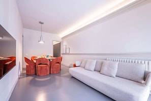 Relax in this stylish living space with a sofa, dining table, and pendant light.