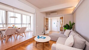 Un salon moderne comprenant un canapé, une table basse et un coin repas avec des chaises et une table.