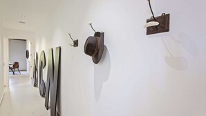 Un couloir agrémenté d’œuvres d’art murales contemporaines et de luminaires modernes.