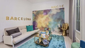 Ein modernes Wohnzimmer mit einer Couch, einem Couchtisch und einem farbenfrohen, abstrakten Wandbild.