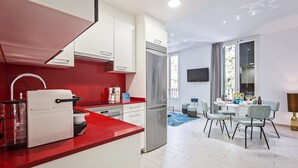 Eine moderne Küche mit roten Arbeitsflächen, einer integrierten Espressomaschine und einem Edelstahl-Kühlschrank.