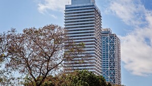 A modern high-rise building with a prominent 'MAPFRE' sign on top. - Sweett | Bogatell Beach (Barcelona)