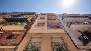 A multi-story residential building with balconies, a brick facade, and a clear sky. - Sweett | Charming in Sant Gervasi (Barcelona)