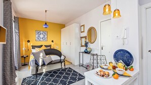 Un dormitorio moderno con cama, mesita de noche y espacio para el desayuno.