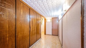 Un pasillo con paneles de madera, piso de baldosas y techo con diseños circulares.