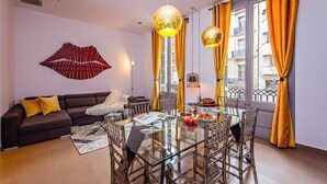 Ein modernes Wohnzimmer mit einem Glastisch, einer Couch und einer Wanddekoration.