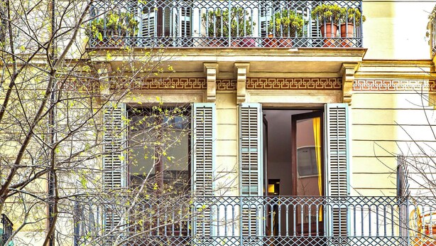 Ein Gebäude mit Balkon, einer Tür und einem Fenster.
