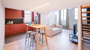 A modern apartment with a kitchen, dining area, living room, and a staircase. - Sweett | Ethnic Eixample (Barcelona)