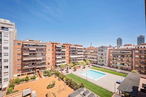 Un immeuble résidentiel doté de nombreux balcons, d’une piscine et d’un jardin sur le toit.