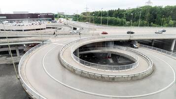 A multi-level highway interchange with a central roundabout, overpasses, and a commercial building labeled "Globus Migros".