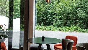 A modern dining area with a round table, four chairs, and hanging pendant lights. - B&B Hotel Zürich East Wallisellen (Wallisellen)