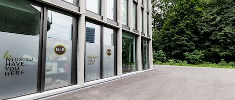 A modern hotel facade with large windows and a welcoming message.