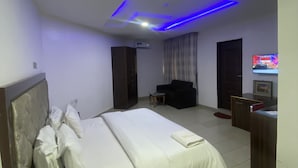 Een moderne hotelkamer met een groot bed, een bureau, een stoel en een televisie.