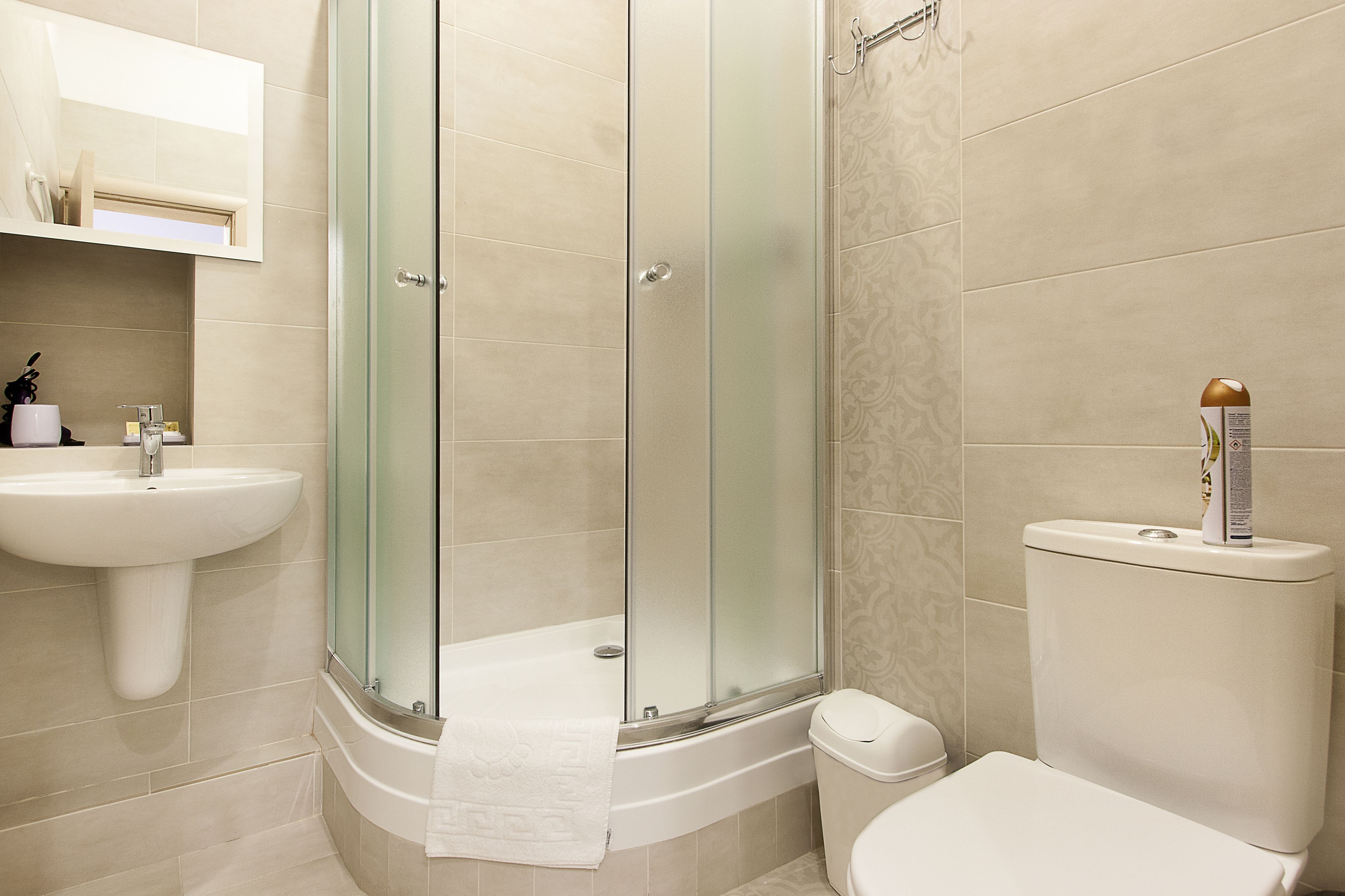 Un bagno con doccia vetrata, lavandino e water.