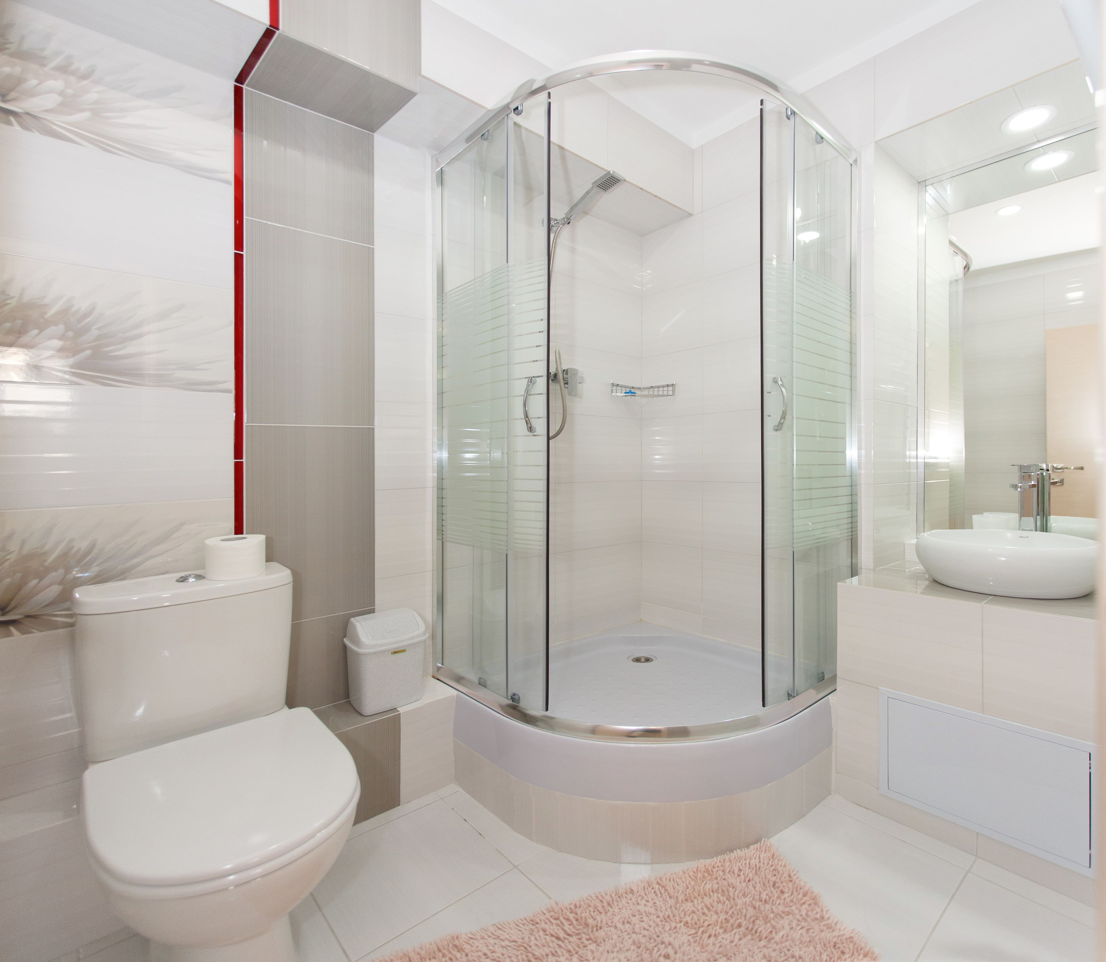 Ein modernes Badezimmer mit einer Duschkabine, einer Toilette und einem Waschbecken.